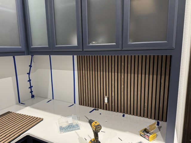 Wood slat backsplash being installed at wet bar